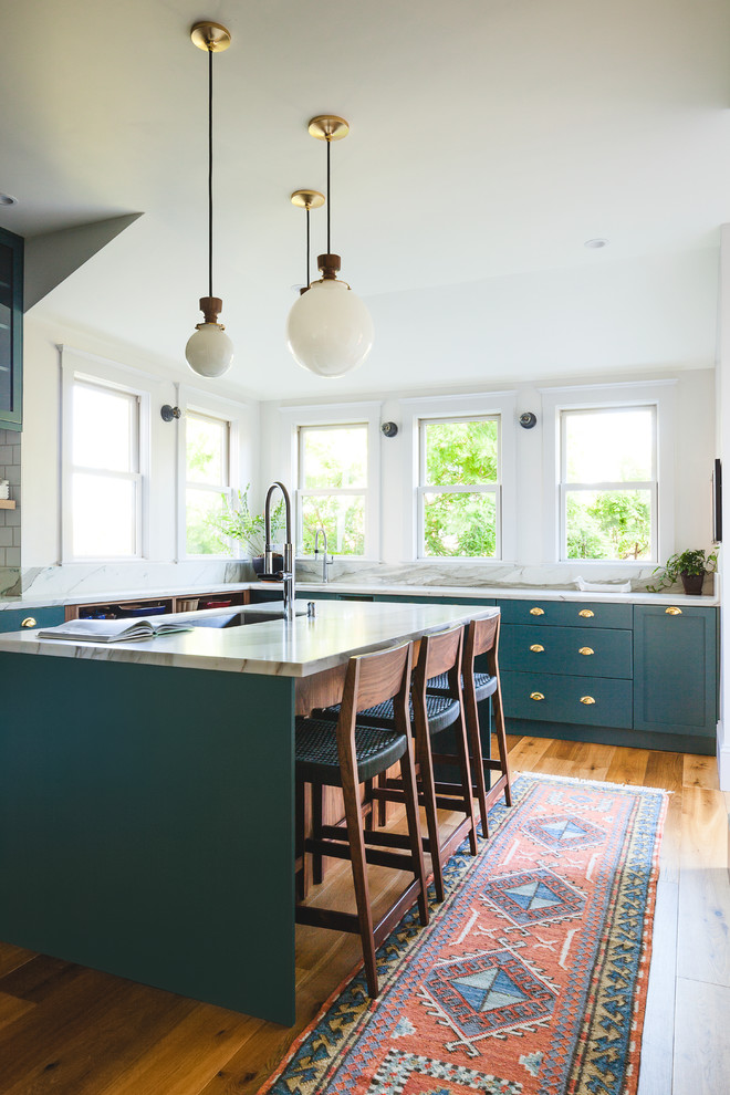 Large transitional u-shaped separate kitchen in San Francisco with an undermount sink, shaker cabinets, green cabinets, marble benchtops, white splashback, ceramic splashback, stainless steel appliances, with island, white benchtop, medium hardwood floors and brown floor.