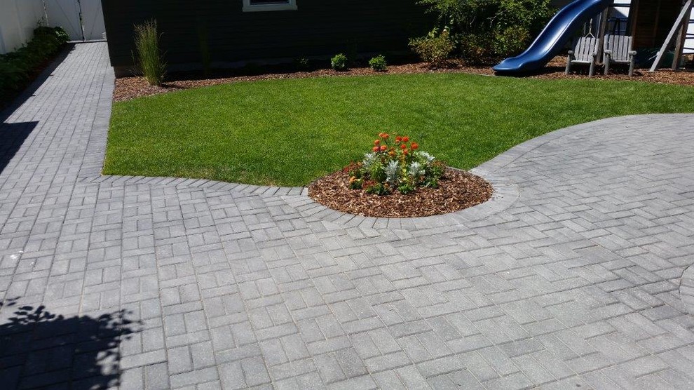 This is an example of a large traditional backyard partial sun driveway in Other with a garden path and natural stone pavers.