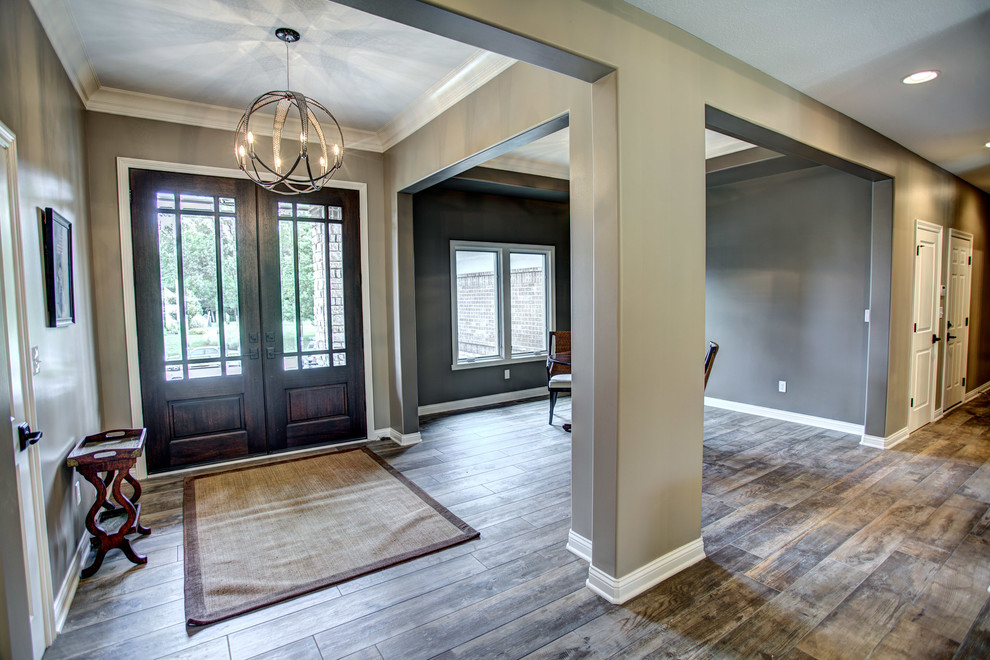 Inspiration for a mid-sized transitional medium tone wood floor and gray floor foyer remodel with gray walls and a brown front door