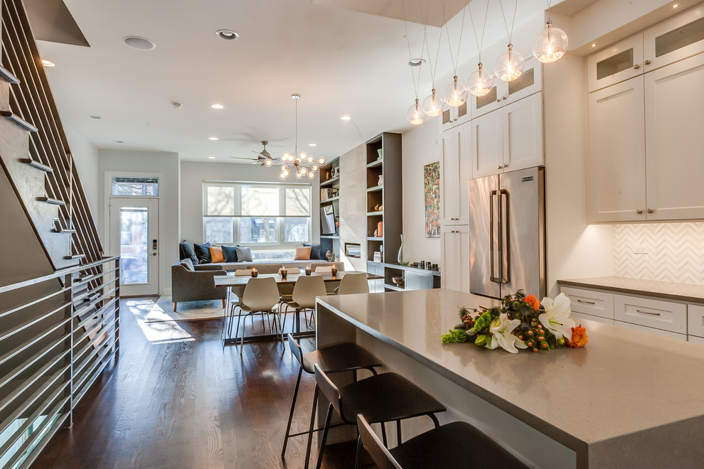 This is an example of a mid-sized contemporary open plan dining in Chicago with a tile fireplace surround, beige walls, dark hardwood floors and a ribbon fireplace.