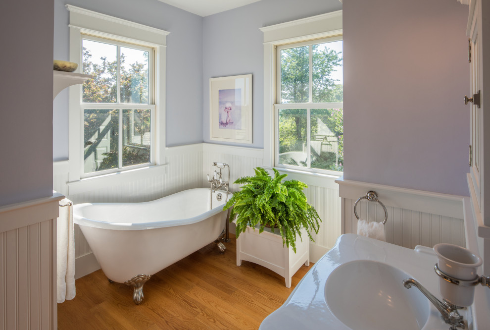 This is an example of a large country master bathroom in DC Metro with white cabinets, a freestanding tub, purple walls, medium hardwood floors, an integrated sink, brown floor, white benchtops, a single vanity and a freestanding vanity.