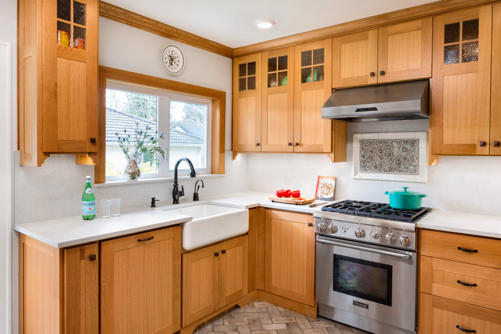 Foto på ett mellanstort funkis vit kök, med en nedsänkt diskho, luckor med profilerade fronter, skåp i ljust trä, tegelgolv, brunt golv, laminatbänkskiva, vitt stänkskydd och rostfria vitvaror