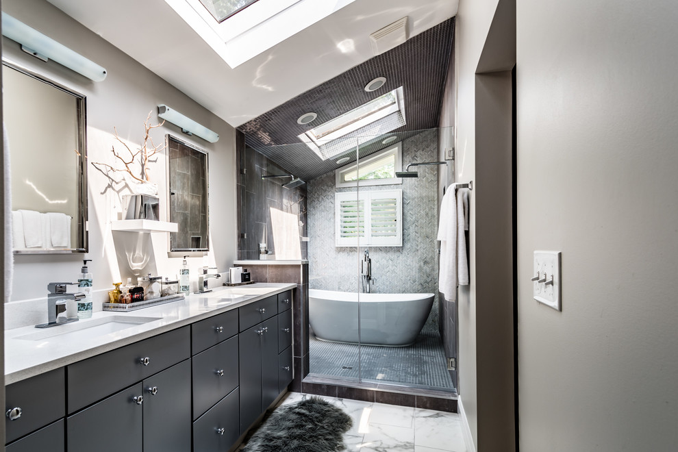 Inspiration for a large contemporary master wet room bathroom in St Louis with flat-panel cabinets, grey cabinets, a freestanding tub, a two-piece toilet, gray tile, porcelain tile, grey walls, porcelain floors, an undermount sink and granite benchtops.