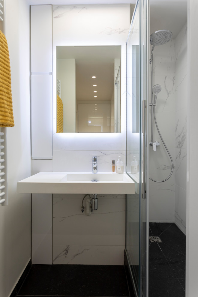 Пример оригинального дизайна: маленькая ванная комната в современном стиле с фасадами с декоративным кантом, белыми фасадами, душем в нише, белой плиткой, мраморной плиткой, белыми стенами, полом из сланца, душевой кабиной, подвесной раковиной, столешницей из талькохлорита, серым полом, душем с раздвижными дверями, белой столешницей, тумбой под одну раковину и встроенной тумбой для на участке и в саду