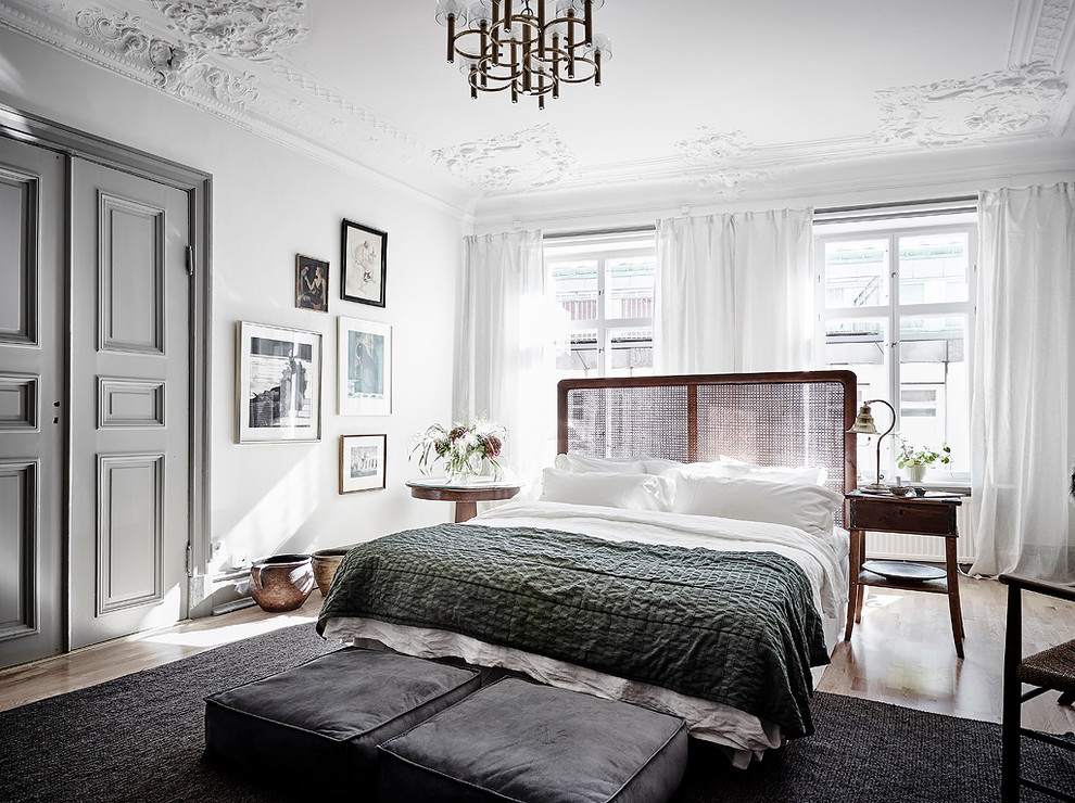 Inspiration for a large traditional bedroom in Gothenburg with white walls and brown floor.