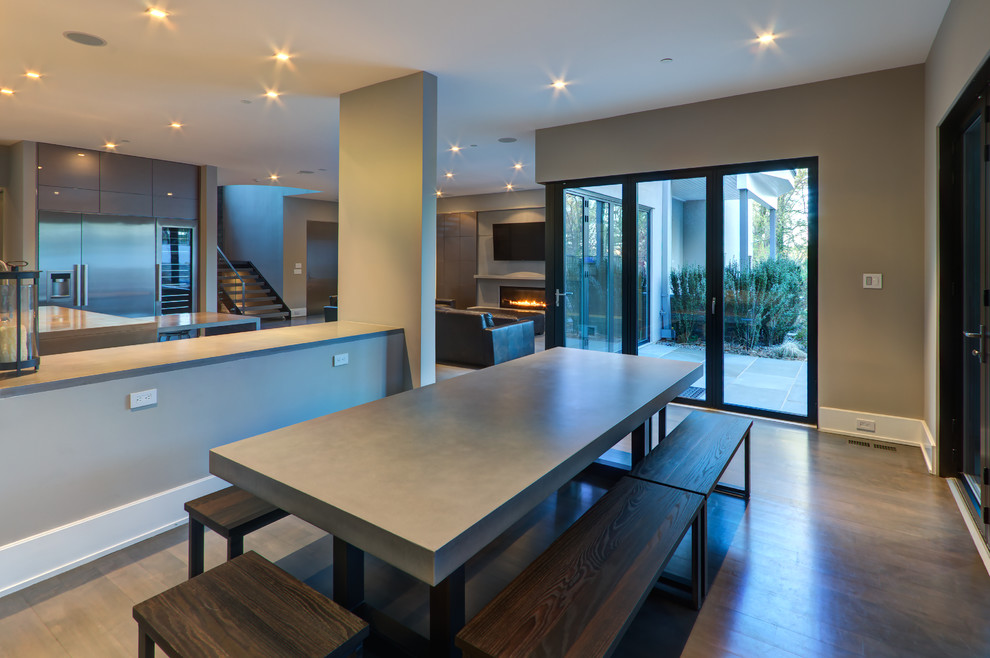 This is an example of a large modern open plan dining in DC Metro with grey walls, medium hardwood floors, a standard fireplace and a metal fireplace surround.