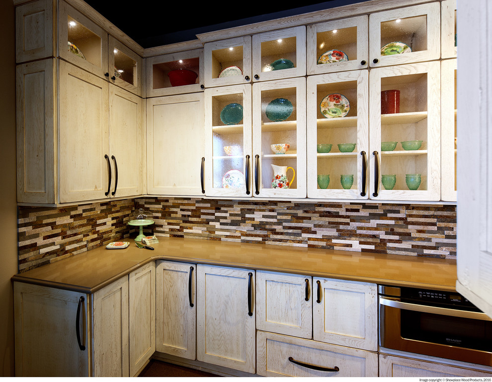 Galley kitchen photo with flat-panel cabinets, stainless steel appliances and no island