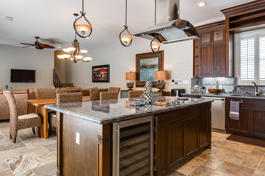 Example of a mid-sized transitional travertine floor eat-in kitchen design in Austin with an undermount sink, granite countertops, stainless steel appliances and an island