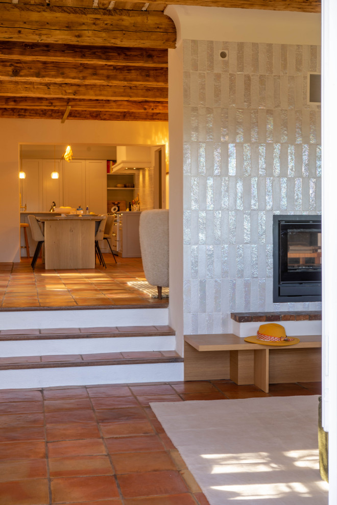 Пример оригинального дизайна: гостиная комната в средиземноморском стиле с полом из терракотовой плитки и деревянным потолком