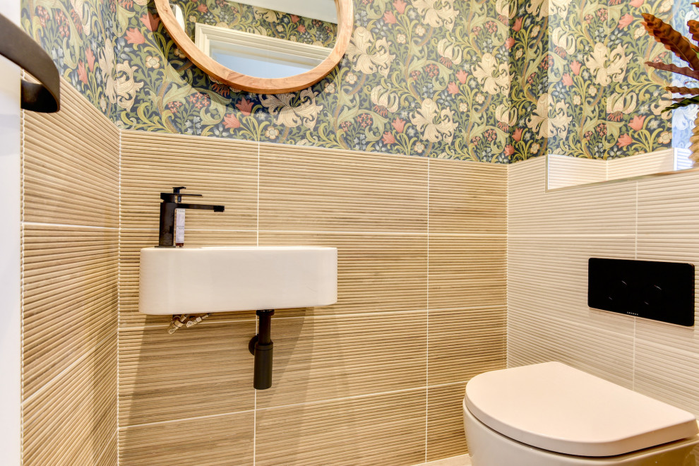 Пример оригинального дизайна: маленький туалет: освещение в стиле модернизм с унитазом-моноблоком, бежевой плиткой, керамической плиткой, разноцветными стенами, полом из керамической плитки, подвесной раковиной, столешницей из плитки, бежевым полом, бежевой столешницей и обоями на стенах для на участке и в саду