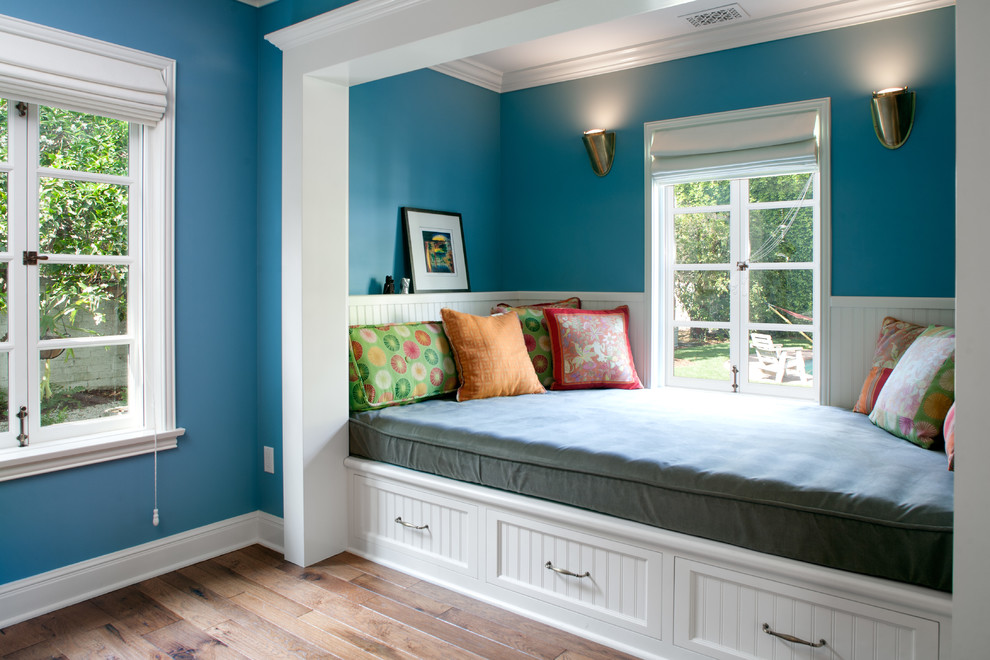This is an example of a large traditional bedroom in Los Angeles with blue walls and medium hardwood floors.