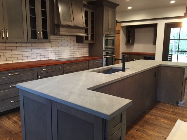 Inspiration for a mid-sized industrial u-shaped separate kitchen in Seattle with an undermount sink, shaker cabinets, grey cabinets, concrete benchtops, white splashback, ceramic splashback, stainless steel appliances, dark hardwood floors, with island and brown floor.