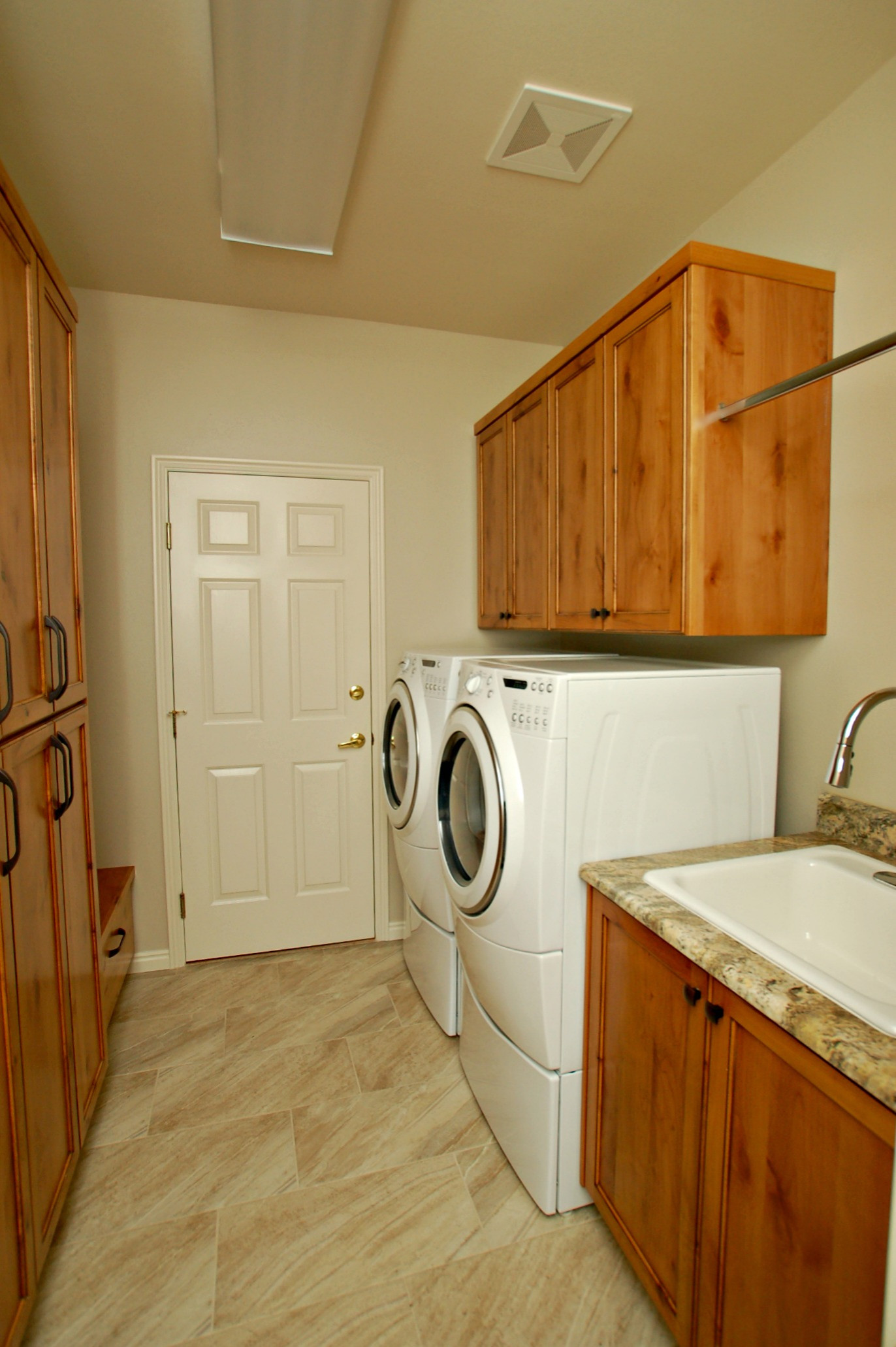 Laundry room with new cabinets, bench and storage.