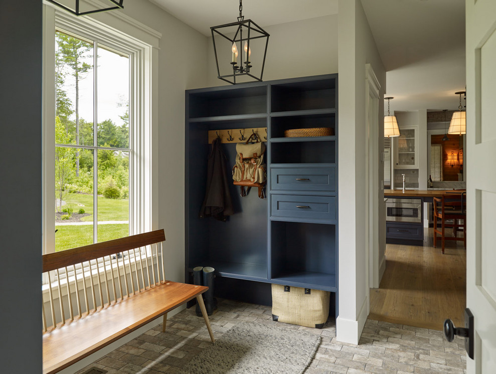 Photo of a mid-sized country mudroom in Portland Maine with white walls and grey floor.