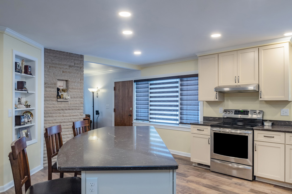 This is an example of a large transitional l-shaped eat-in kitchen in Other with an undermount sink, shaker cabinets, yellow cabinets, quartz benchtops, stainless steel appliances, vinyl floors, with island, brown floor and brown benchtop.