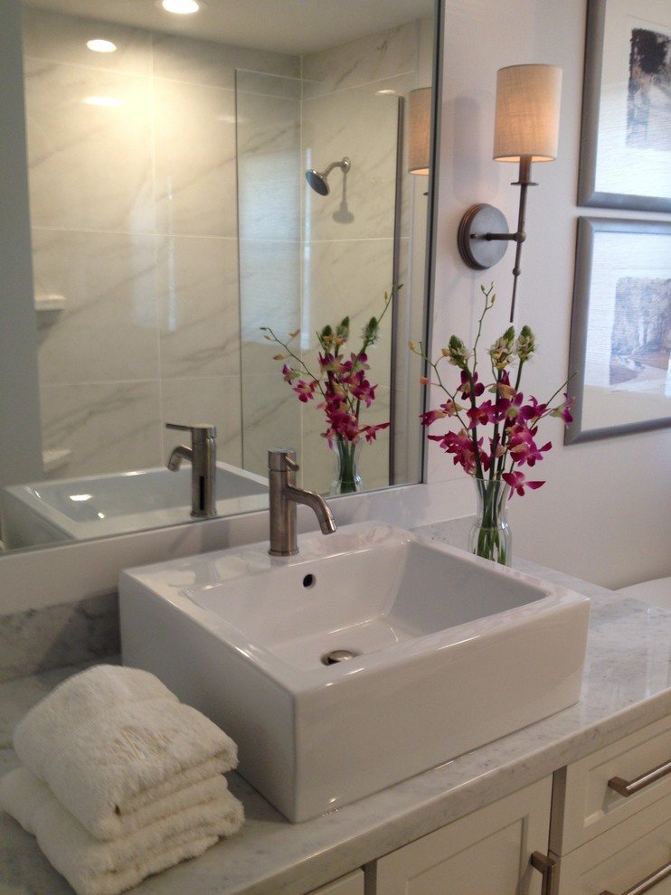Inspiration for a mid-sized contemporary master bathroom in Houston with a vessel sink, shaker cabinets, white cabinets, marble benchtops, a freestanding tub, an open shower, a one-piece toilet, white tile, porcelain tile, grey walls and travertine floors.