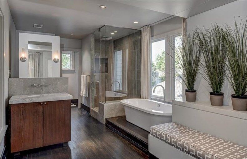 Mid-sized contemporary master bathroom in Atlanta with flat-panel cabinets, dark wood cabinets, a freestanding tub, an alcove shower, a two-piece toilet, beige tile, ceramic tile, grey walls, dark hardwood floors, an undermount sink and concrete benchtops.