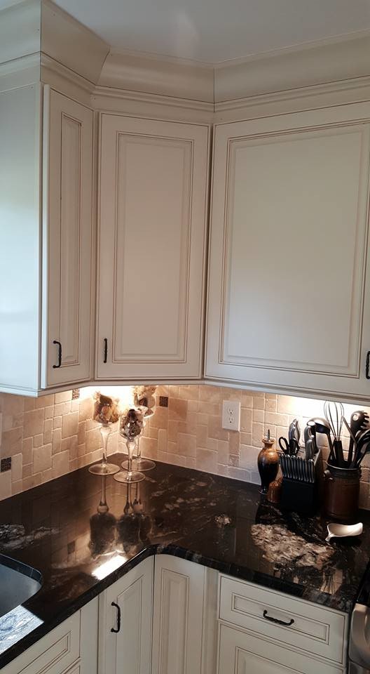 Inspiration for a mid-sized transitional l-shaped dark wood floor kitchen remodel in Baltimore with white cabinets, beige backsplash, stainless steel appliances and an island
