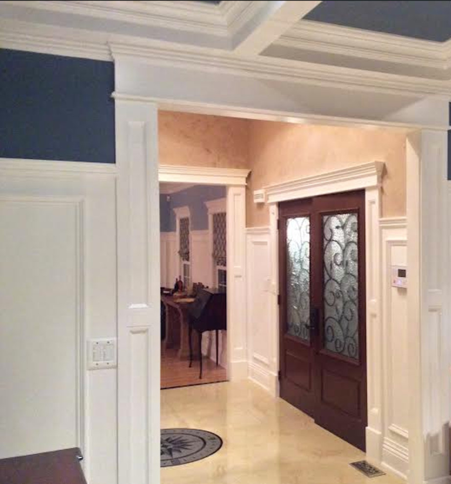 This is an example of a mid-sized traditional front door in New York with a double front door, a dark wood front door, beige walls, linoleum floors and multi-coloured floor.