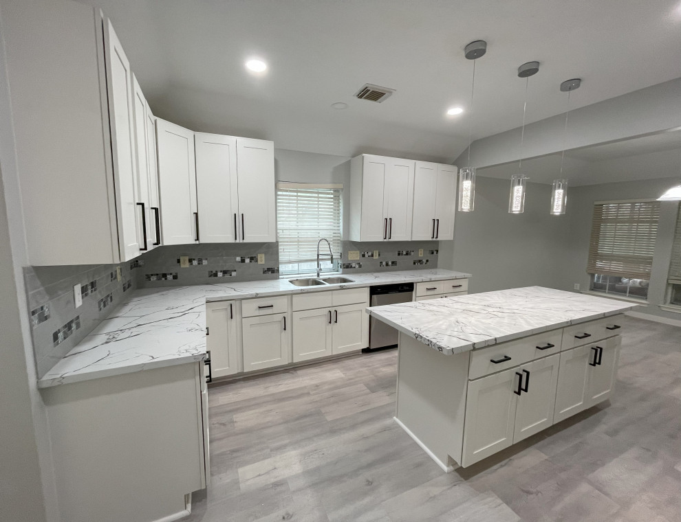 Design ideas for a large contemporary kitchen in Houston with shaker cabinets, white cabinets, engineered stone countertops, grey splashback, porcelain splashback, an island and white worktops.