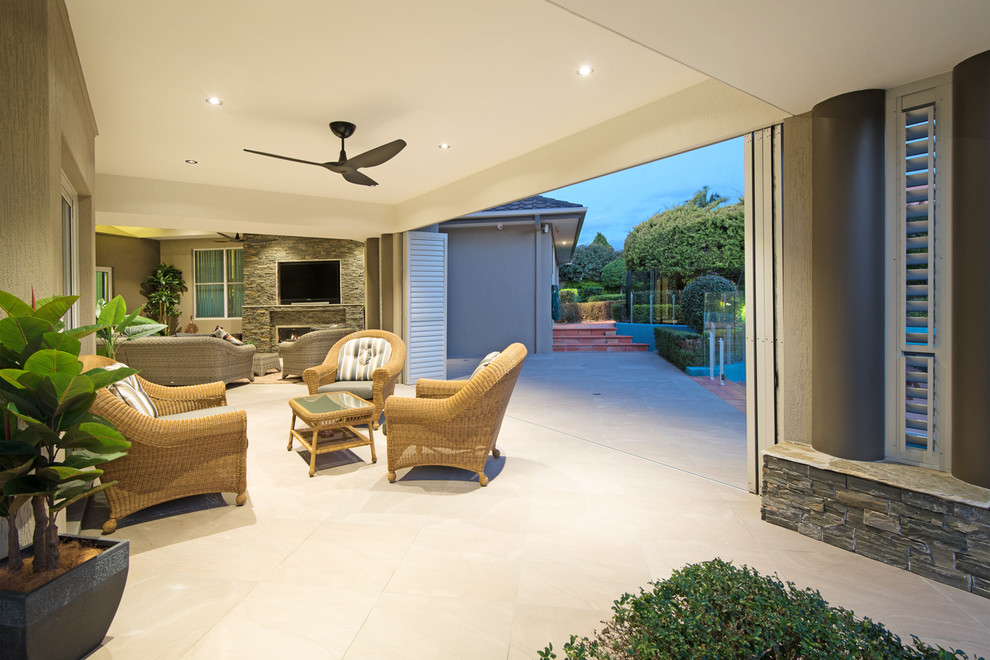 Photo of a mid-sized contemporary backyard patio in Brisbane with natural stone pavers and a roof extension.