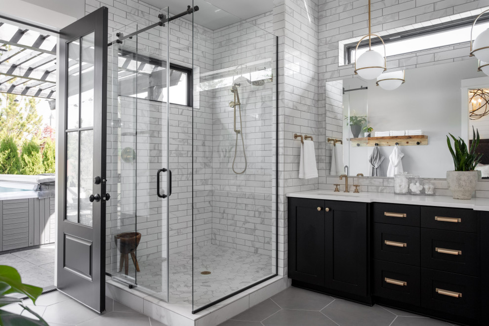 Design ideas for a mid-sized contemporary master bathroom in Portland with black cabinets, a corner shower, white tile, subway tile, white walls, ceramic floors, an undermount sink, grey floor, a sliding shower screen, white benchtops and shaker cabinets.