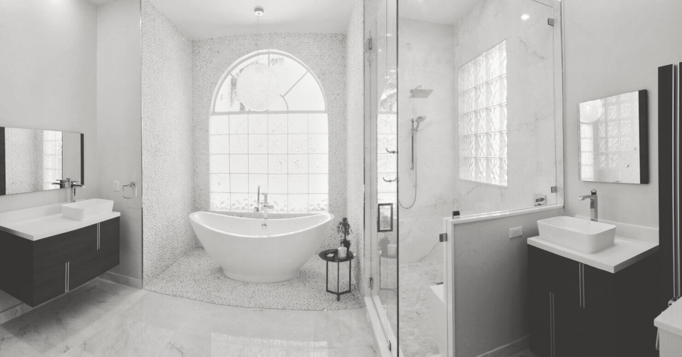 Идея дизайна: большая главная, серо-белая ванная комната в современном стиле с настольной раковиной, тумбой под одну раковину, напольной тумбой, фасадами в стиле шейкер, черными фасадами, отдельно стоящей ванной, душевой комнатой, унитазом-моноблоком, белой плиткой, плиткой из сланца, белыми стенами, мраморным полом, столешницей из кварцита, белым полом, душем с распашными дверями, белой столешницей, окном, многоуровневым потолком и панелями на части стены