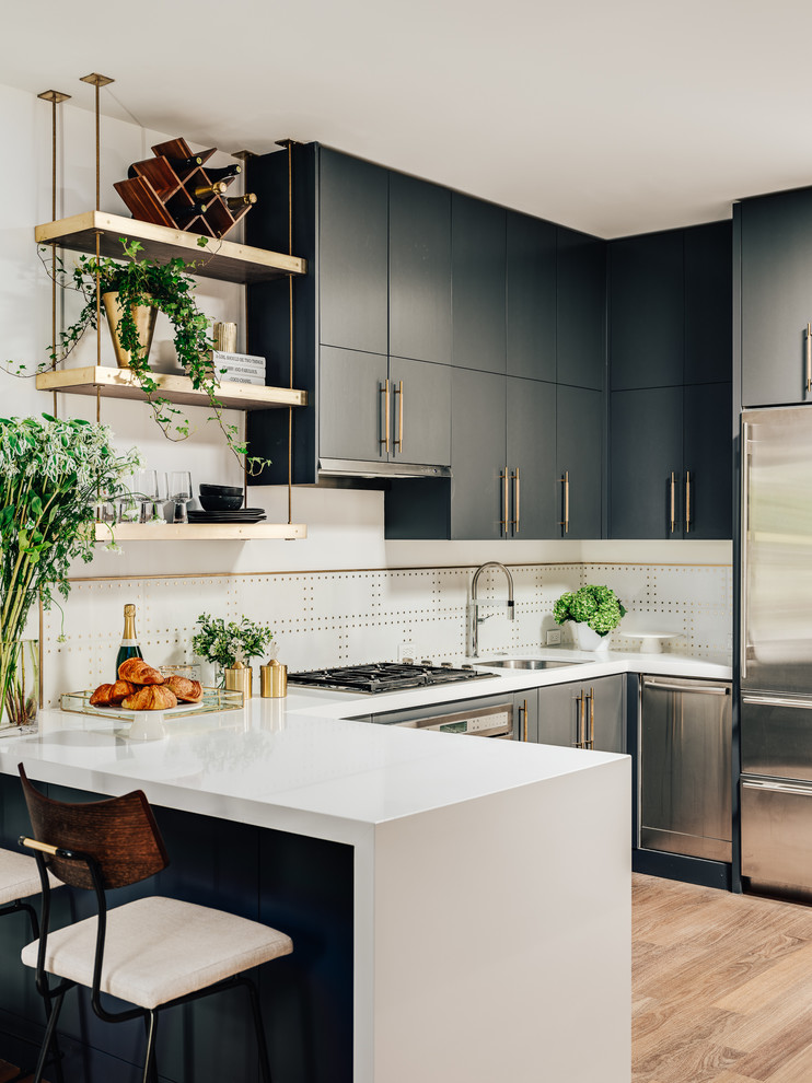 Contemporary u-shaped kitchen in San Francisco with an undermount sink, flat-panel cabinets, grey cabinets, quartz benchtops, white splashback, marble splashback, stainless steel appliances, medium hardwood floors, white benchtop, a peninsula and brown floor.