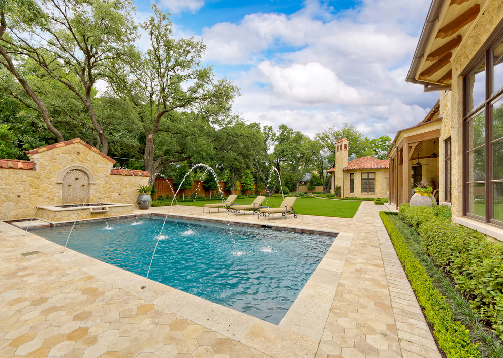 Photo of a mediterranean rectangular pool in Dallas with a water feature.