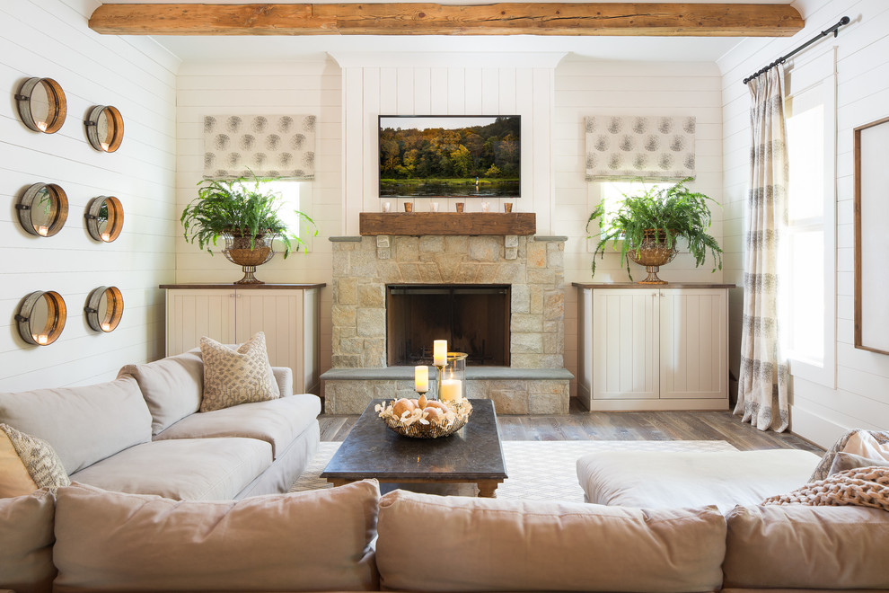Design ideas for a large country family room in Atlanta with white walls, a standard fireplace, a stone fireplace surround, a wall-mounted tv and dark hardwood floors.
