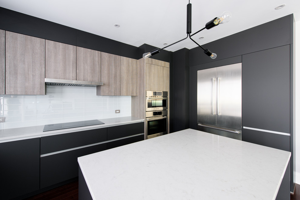 This is an example of a mid-sized modern u-shaped eat-in kitchen in Toronto with an undermount sink, flat-panel cabinets, black cabinets, white splashback, stainless steel appliances, with island, brown floor and white benchtop.