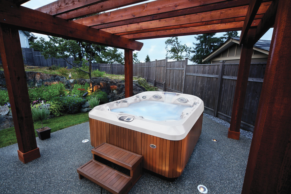 This is an example of a small traditional backyard rectangular aboveground pool in Tampa with a hot tub and gravel.