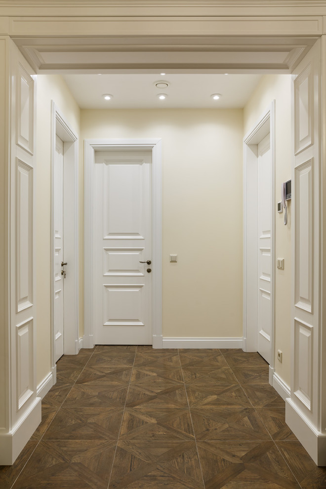 Cette photo montre un couloir avec un mur beige, un sol en carrelage de porcelaine, un sol marron, un plafond décaissé et du lambris.