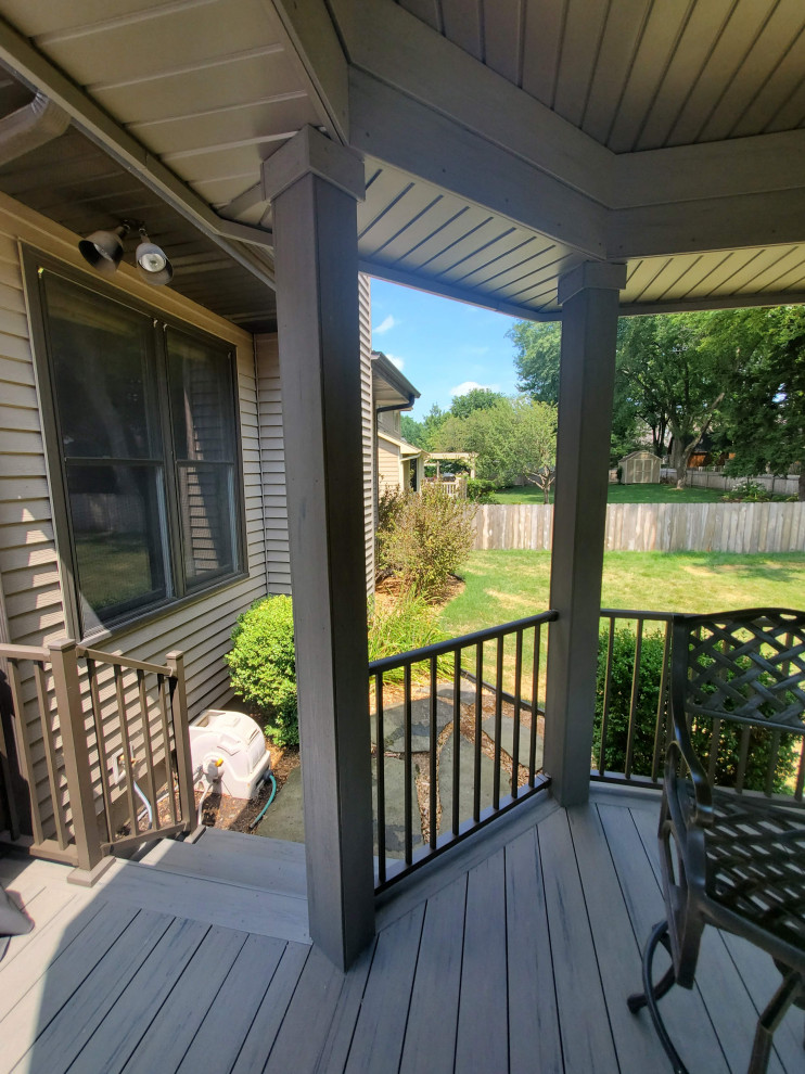 Photo of a mid-sized backyard and ground level deck in Other with with privacy feature, a roof extension and metal railing.