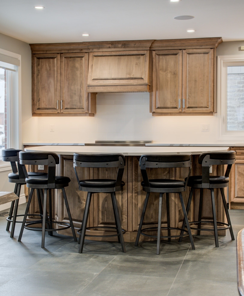 Eat-in kitchen - mid-sized transitional l-shaped eat-in kitchen idea in Toronto with an undermount sink, raised-panel cabinets, medium tone wood cabinets, quartz countertops, white backsplash, ceramic backsplash, stainless steel appliances, an island and white countertops