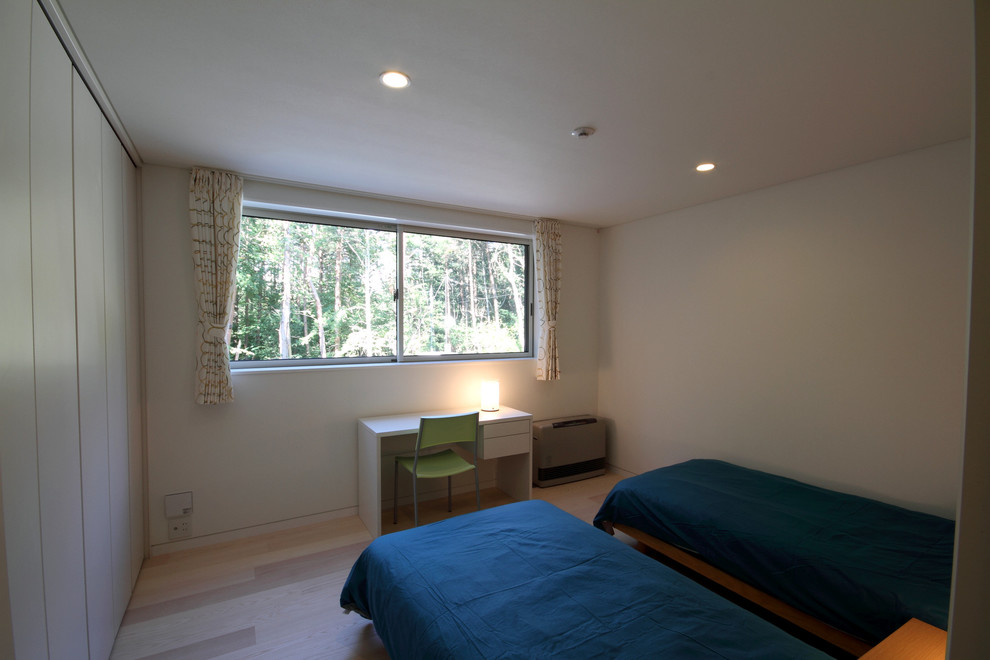 Ejemplo de dormitorio moderno de tamaño medio con paredes blancas, suelo de contrachapado y suelo marrón