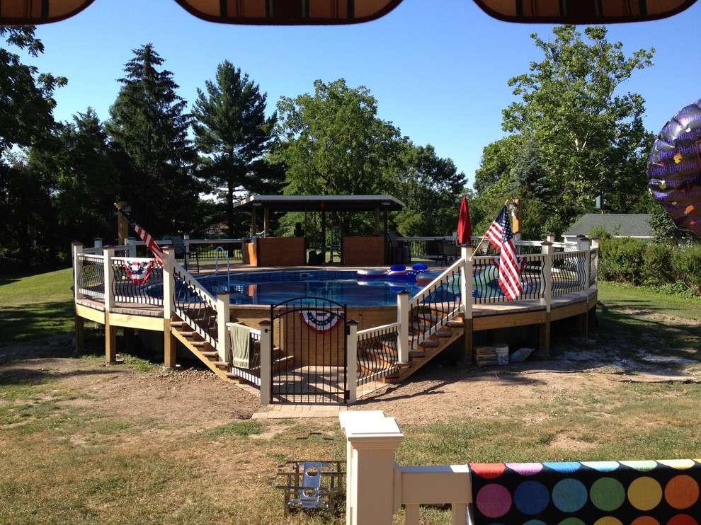 Inspiration for a large rustic backyard stone and round aboveground pool remodel