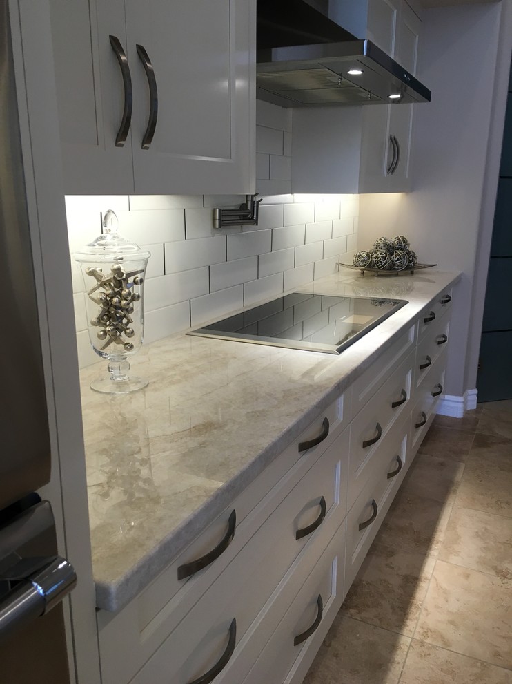 Inspiration for a contemporary kitchen in Phoenix with an undermount sink, shaker cabinets, beige cabinets, quartzite benchtops, metallic splashback, metal splashback, stainless steel appliances, travertine floors and with island.