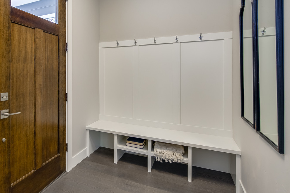 Example of a small transitional light wood floor and beige floor foyer design with beige walls and a dark wood front door