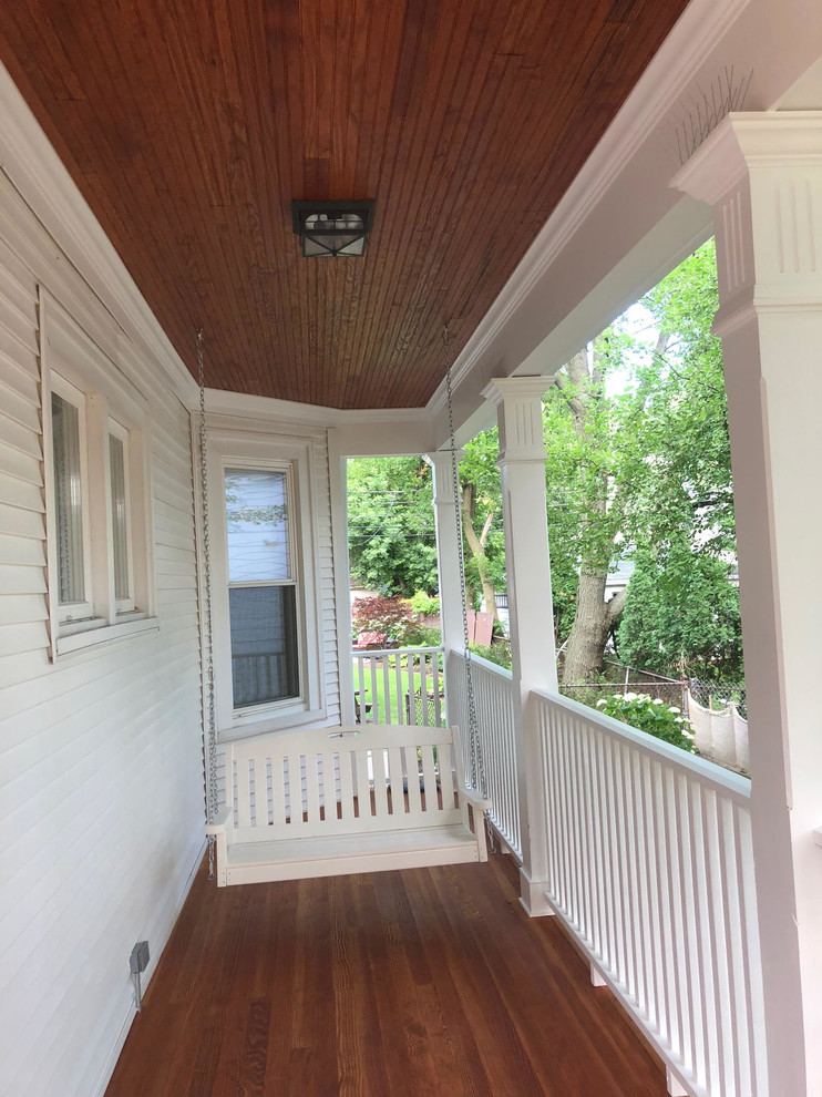 Photo of a traditional front yard verandah in Boston with a roof extension.
