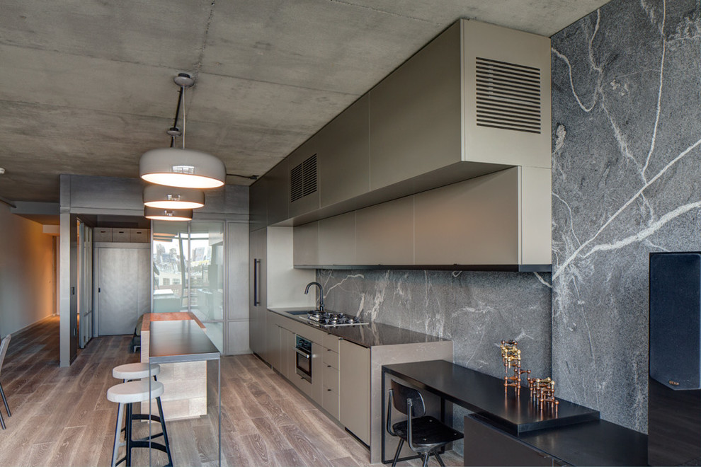 Example of a large minimalist single-wall light wood floor and brown floor eat-in kitchen design in Portland with an undermount sink, flat-panel cabinets, dark wood cabinets, quartz countertops, gray backsplash, stone slab backsplash, stainless steel appliances and an island