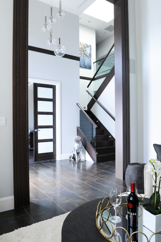 Design ideas for a transitional foyer in Vancouver with white walls and brown floor.