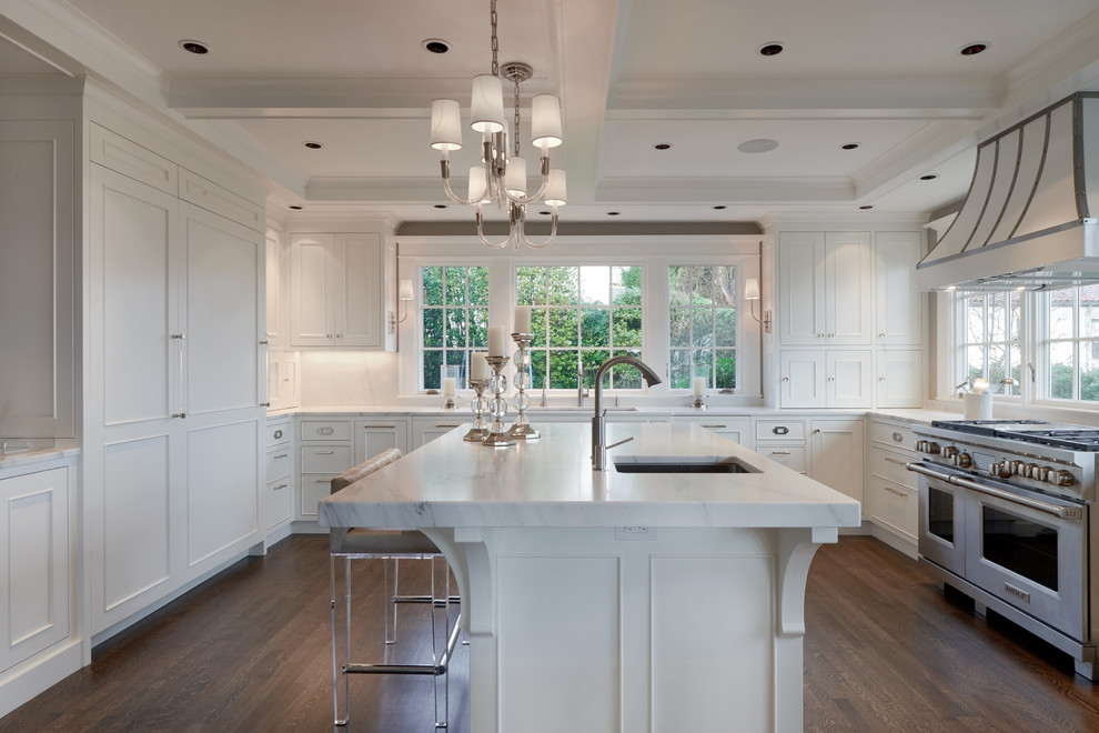 Inspiration for a large traditional u-shaped separate kitchen in Portland with an undermount sink, recessed-panel cabinets, white cabinets, marble benchtops, white splashback, with island, stainless steel appliances, dark hardwood floors and brown floor.