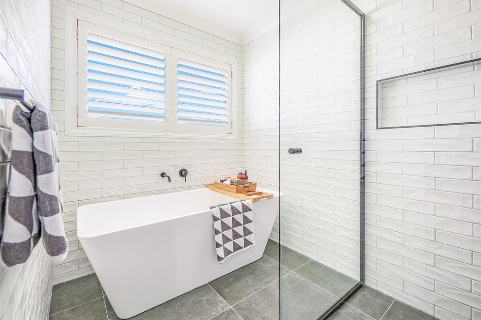 This is an example of a mid-sized contemporary master bathroom in Brisbane with a freestanding tub, an open shower, white tile, ceramic tile, white walls, ceramic floors, green floor and an open shower.