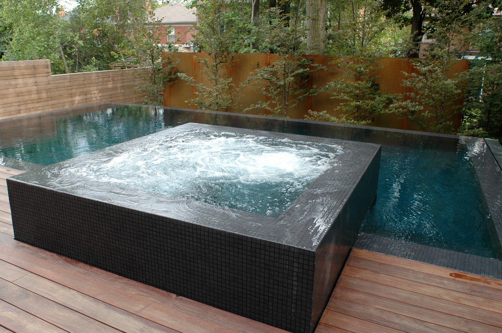 Inspiration for a large modern backyard rectangular infinity hot tub remodel