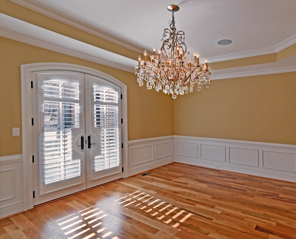 This is an example of an expansive separate dining room in Richmond with yellow walls and light hardwood floors.