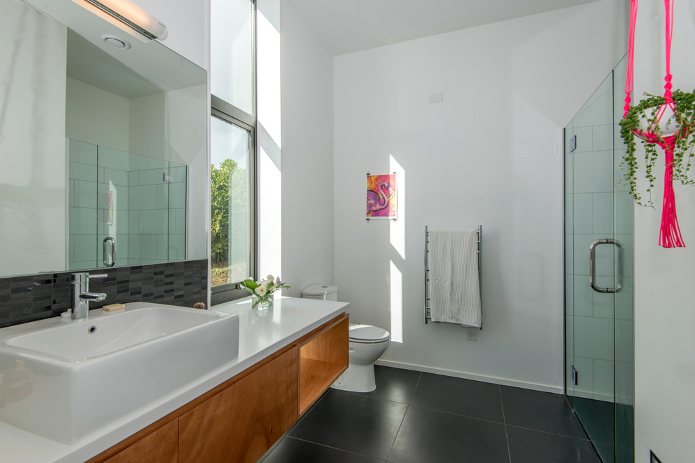 Inspiration for a mid-sized contemporary master bathroom in Christchurch with medium wood cabinets, an alcove shower, a one-piece toilet, black and white tile, ceramic tile, white walls, ceramic floors, a vessel sink, open cabinets and engineered quartz benchtops.