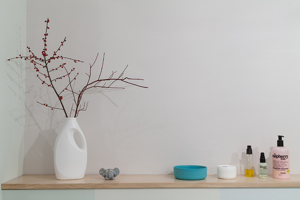 Kleines Modernes Duschbad mit flächenbündigen Schrankfronten, weißen Schränken, Eckdusche, Wandtoilette, weißer Wandfarbe, Keramikboden, Wandwaschbecken, weißem Boden und Falttür-Duschabtrennung in Berlin