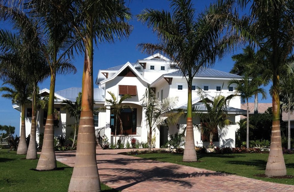 Inspiration for a large tropical three-storey stucco white house exterior in Tampa with a hip roof and a metal roof.