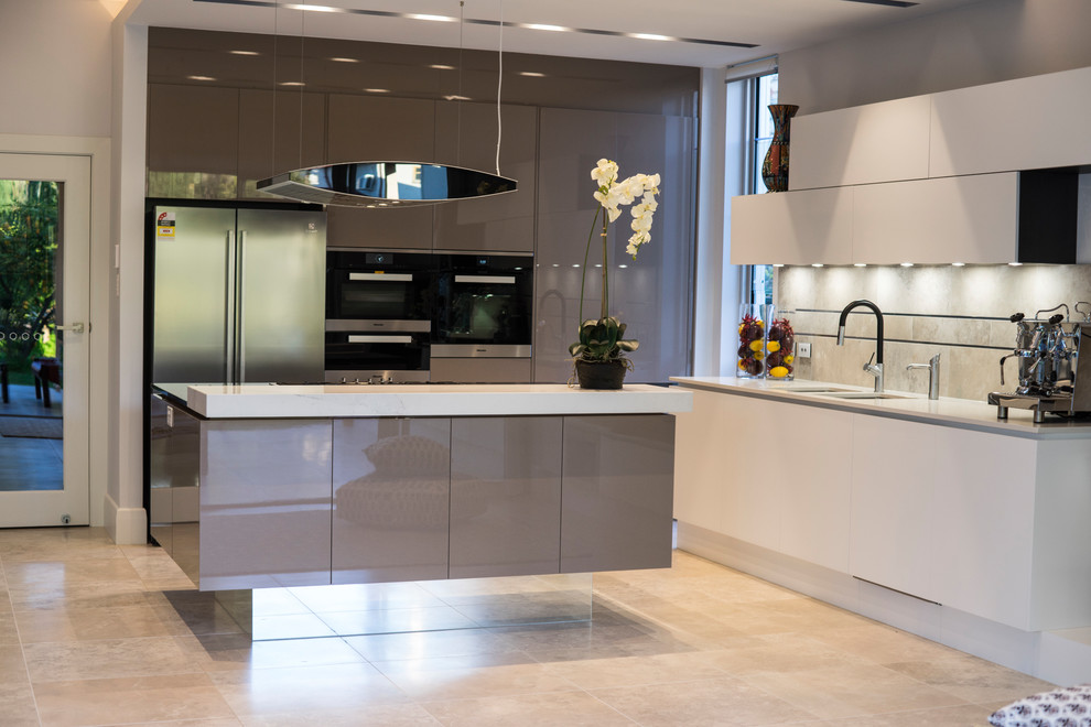 Contemporary l-shaped kitchen in Adelaide with a double-bowl sink, flat-panel cabinets, grey cabinets, beige splashback, stainless steel appliances, with island and beige floor.
